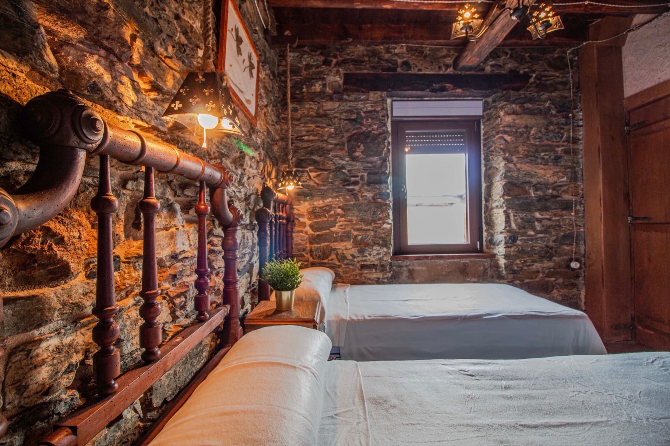 Dormitorio de piedra con radiador antiguo y cama de madera