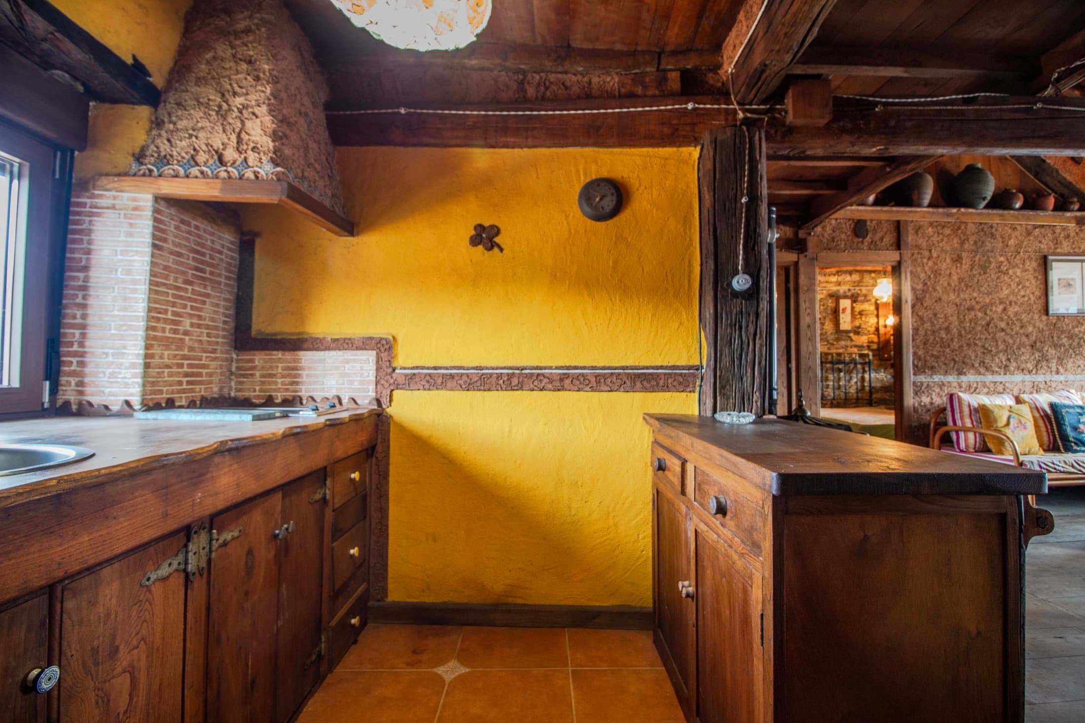 Cocina amarilla abierta al comedor y la chimenea