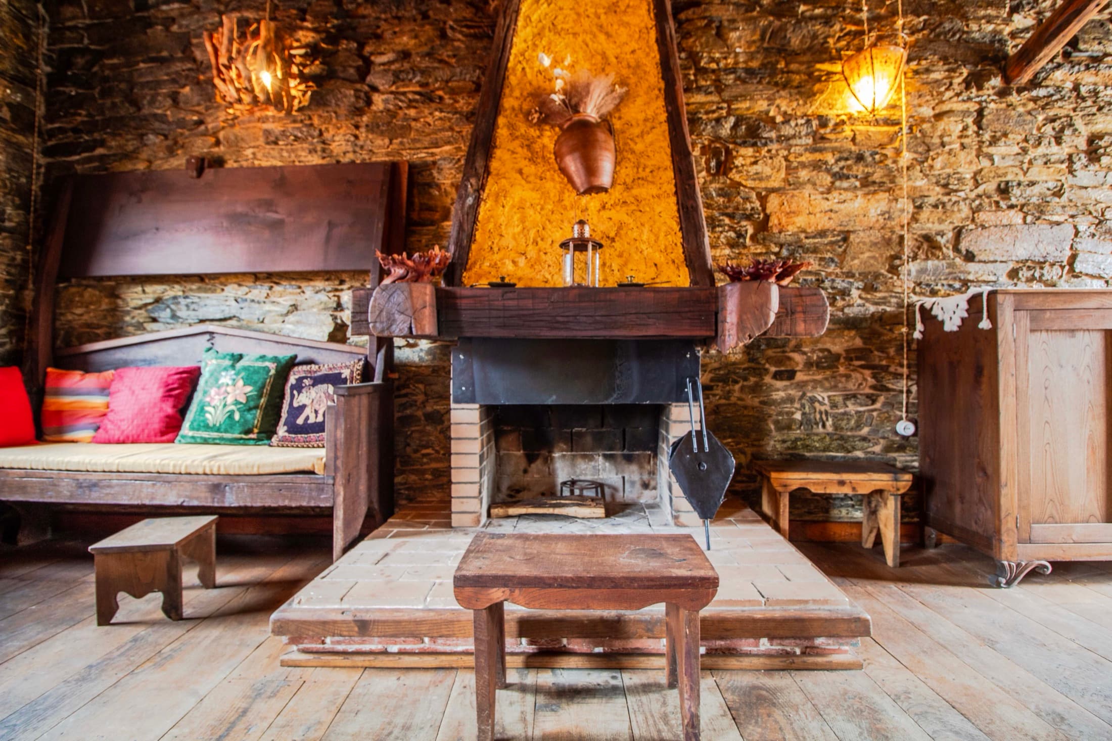 Salón con chimenea de piedra y sofá