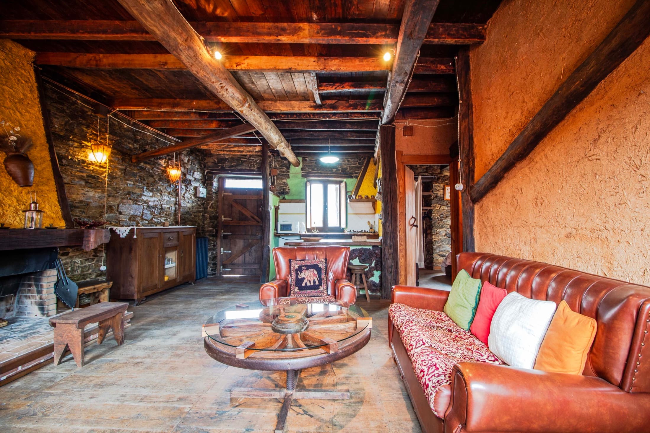 Salón amplio con chimenea, sofás y cocina al fondo